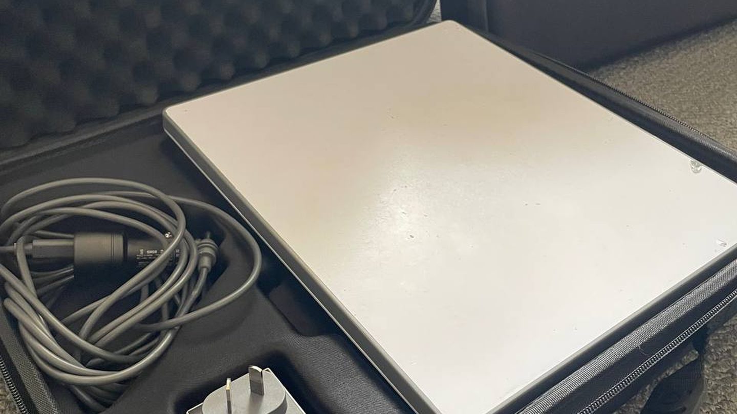 An Offgrid Internet Starlink Mini hire kit open in its padded hard case, showing the dish, a coiled power cable and the Australian plug power supply
