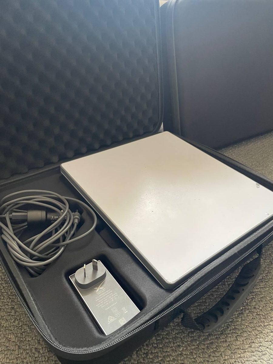 The hire kit packed back into its case, dish seated in the foam tray with the power supply in its cutout